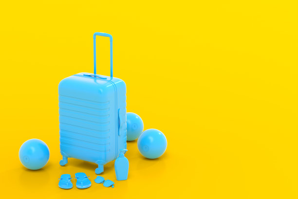 黄色背景的彩色手提箱或行李与海滩配件。图片下载