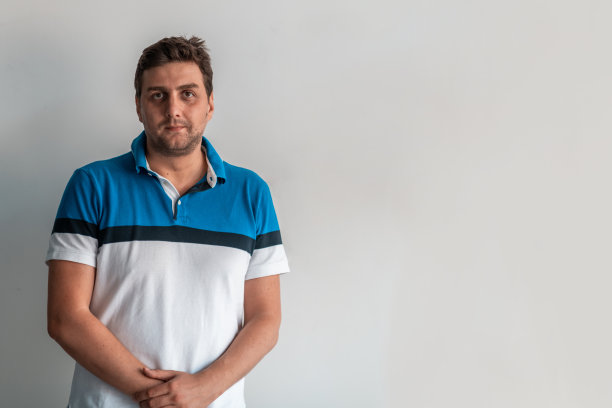 正式的商业男性肖像。一个自信的、成功的、随意的商人或经理站在白色背景前，双臂交叉，直视镜头，友好地微笑着。高质量的摄影图片下载