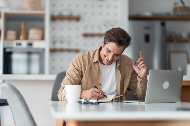 一个中年男子想出了一个好主意，他要把它写在笔记本上。图片下载