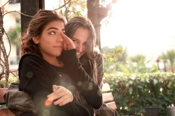 户外肖像的两个美丽快乐的黑发年轻女性在公园在阳光明媚的一天图片下载