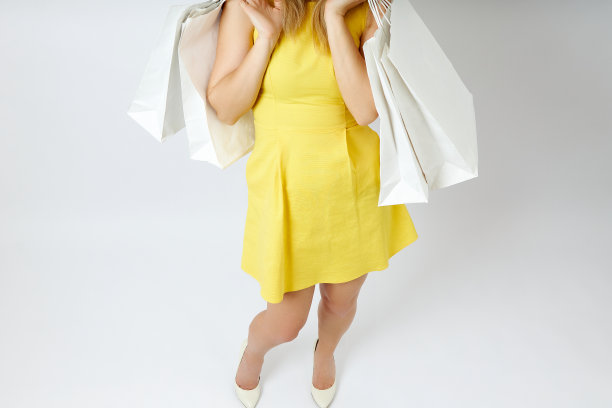美丽的腿年轻女人购物袋在白色的背景图片下载