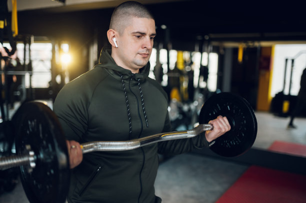 男人在健身房训练，举杠铃图片下载