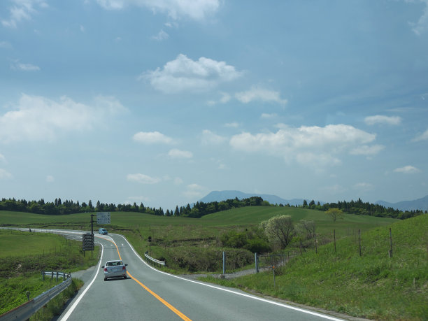 在阳光明媚的日子里，驾车穿过绿色的山谷图片下载