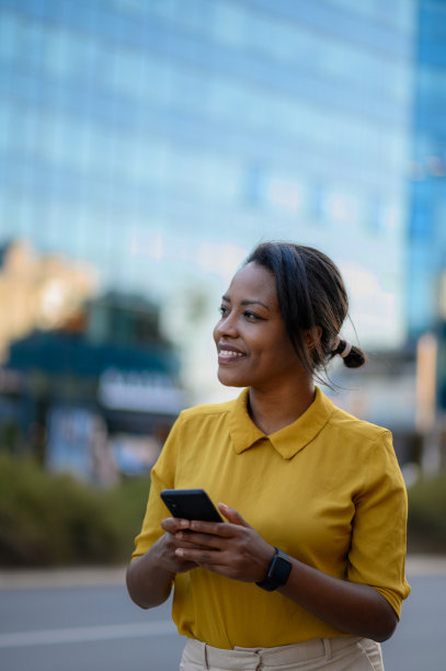 非裔美国妇女在城市中使用智能手机图片下载