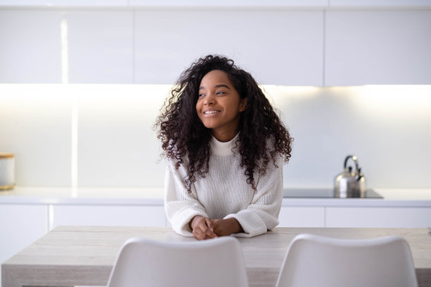 肖像美丽的非洲裔美国黑人女孩在现代家庭微笑的年轻女子卷发看着相机图片下载