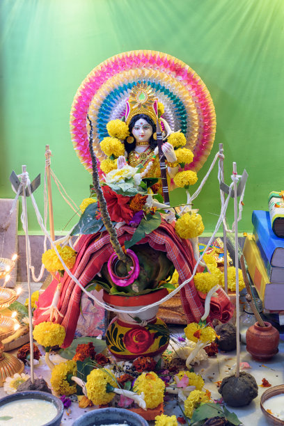 女神萨拉瓦蒂神像与宗教祭品的图片，萨拉瓦蒂象征着创造的能量，被认为是知识、音乐、艺术、智慧和学习的女神。图片下载