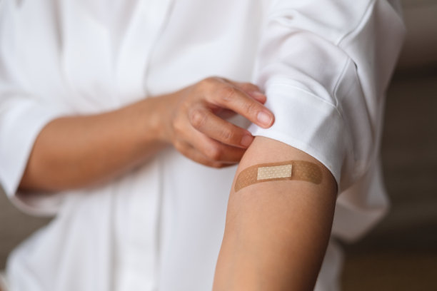一个女人的特写照片，她的胳膊上有粘胶绷带、医用石膏和创可贴图片下载