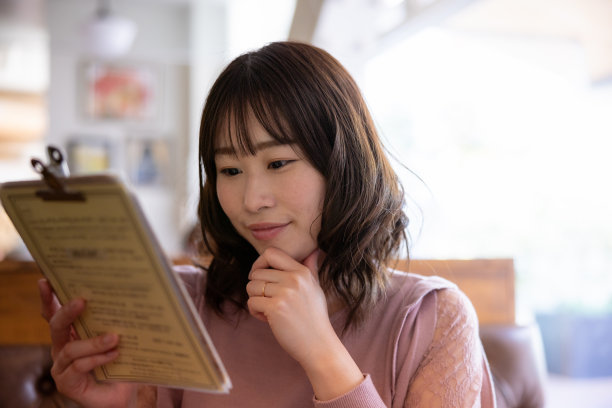 在餐馆看午餐菜单的女人图片下载