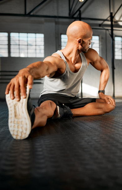 一个年轻人在锻炼前伸展他的腿图片下载