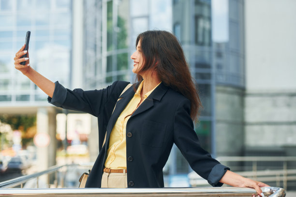 白天穿着正式服装的快乐女人站在城市的户外图片下载