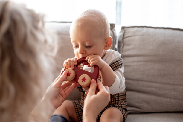 小可爱的照片。紧紧地拿着微型木车玩具和红星。玩的母亲。图片下载