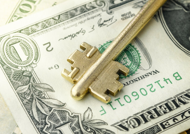 在美元钞票上的钥匙的特写。买房或租房的概念。图片下载
