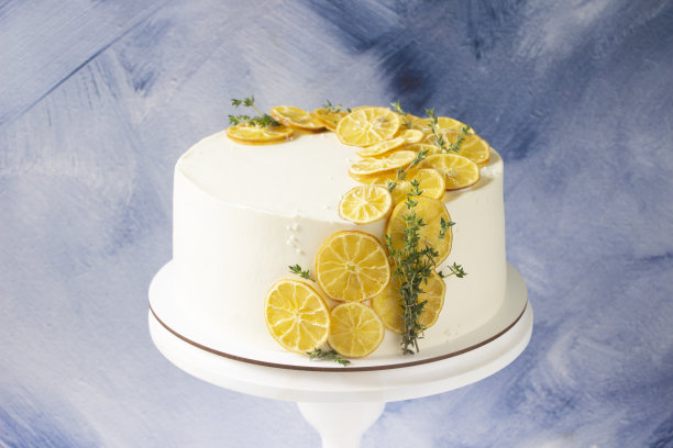 摆上装饰着干柠檬片和百里香的白色蛋糕。柠檬蛋糕，食谱菜单模板图片下载