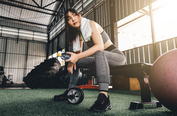 有吸引力的健身妇女坐在椅子上，休息后锻炼在健身中心。女性在剧烈有氧运动后休息图片下载