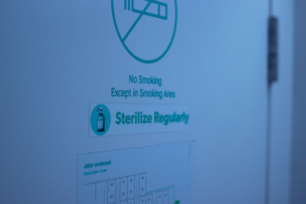 万隆的一家胶囊旅馆上写着“禁止吸烟”的标志，上面有“定期消毒”的文字和“疏散路线”的文字图片下载