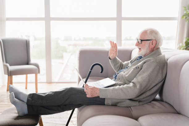 在线视频电话会议。白种人老人老人爷爷使用笔记本电脑与朋友交谈，孙辈，在家里的社交距离概念。图片下载