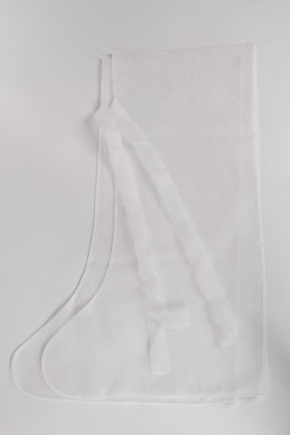 护士穿一次性长袍和一次性鞋套。医生穿上白色医用鞋套，特写镜头。医院就诊服装或医疗制服概念。套鞋保护图片下载