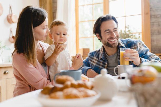 幸福的家庭的时刻。白种人年轻的父母正在吃早餐，带着小孩，小孩，蹒跚学步的儿子，女儿，婴儿，婴儿在家里厨房里。生育和收养图片下载