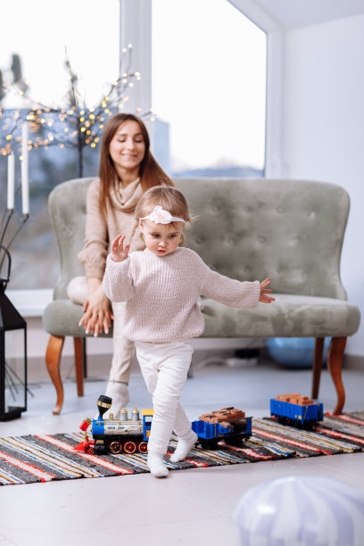 母亲的一天。学前班的小女孩孩子兴奋的年轻妈妈在工作室一起玩得很开心，快乐的妈妈和女儿拥抱拥抱秀爱，享受一家人玩火车图片下载