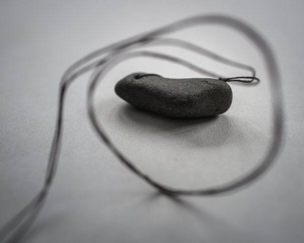 黑色的石头项链与圆形的字符串在白色的背景图片下载