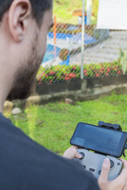 一名男子从上方驾驶无人机，从屏幕上观看它图片下载