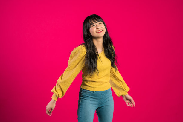 幸福的女人张开的手在前面的粉红色。图片下载