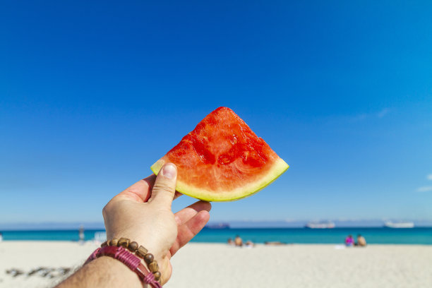 男子在迈阿密海滩吃西瓜视角图片下载