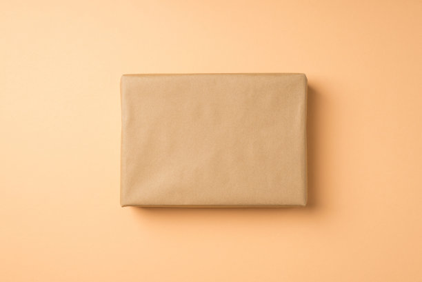 顶视图照片的牛皮纸礼品盒在孤立的米色背景与copyspace图片下载