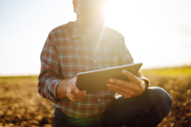 农夫拿着石板在田里。农业、园艺或生态学概念。聪明的农场。图片下载