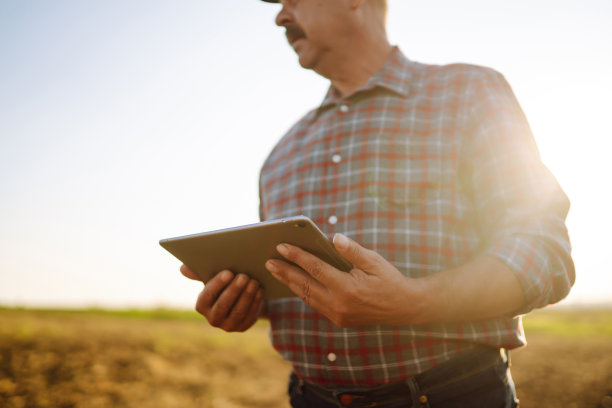 农夫拿着石板在田里。农业、园艺或生态学概念。聪明的农场。图片下载