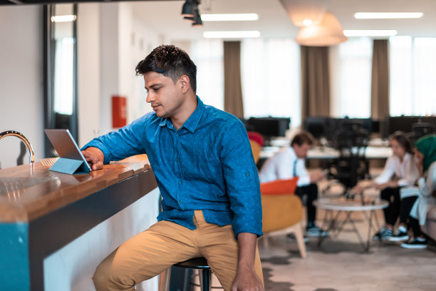 休闲商务人士，戴着耳机在笔记本电脑上开会。有选择性的重点图片下载