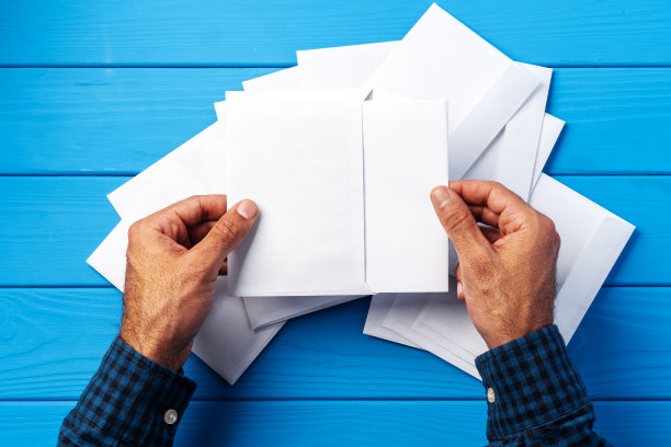 商业信函。俯视图的男子手握模型信封和信件。副本的空间。图片下载