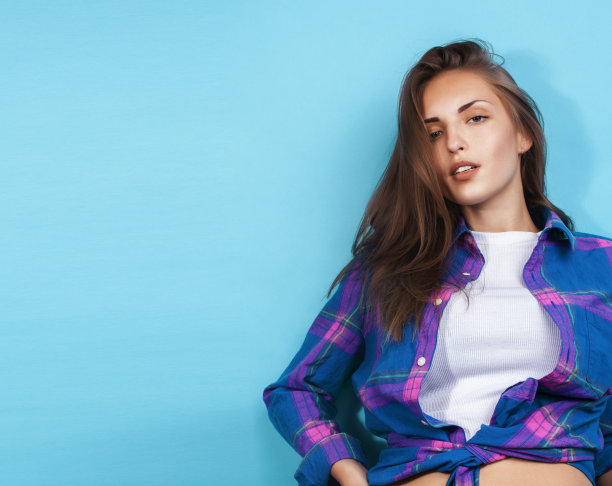年轻漂亮的时髦女孩摆出情绪快乐的蓝色背景，生活方式的人的概念图片下载