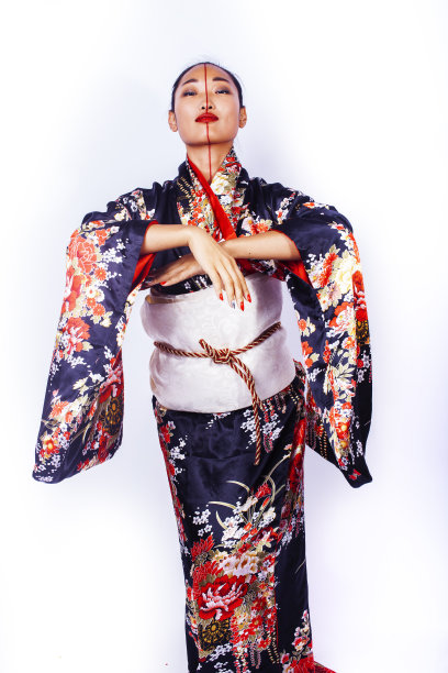 年轻漂亮的艺妓穿着黑色和服在白人背景下摆姿势，亚裔图片下载