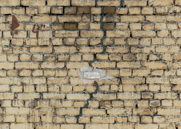 砖墙上的标志，用于监测建筑物裂缝的扩展。图片下载