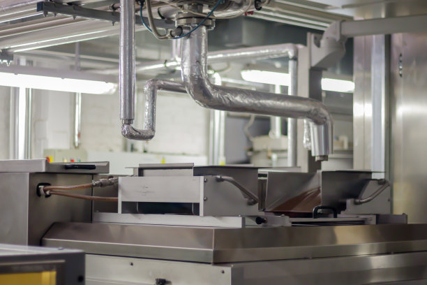 一家工业工厂生产巧克力的生产线。糖果生产线的自动化加工。巧克力工厂生产过程中的图片。带糖果的输送带图片下载