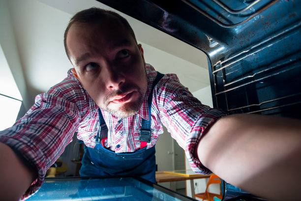 勤杂工在烤箱里搜索探测器图片下载