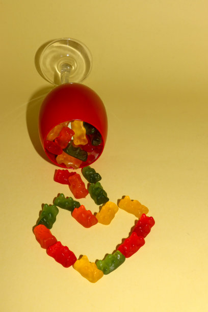 一个红色的杯子，里面有软糖掉出来，做成一个心形图片下载