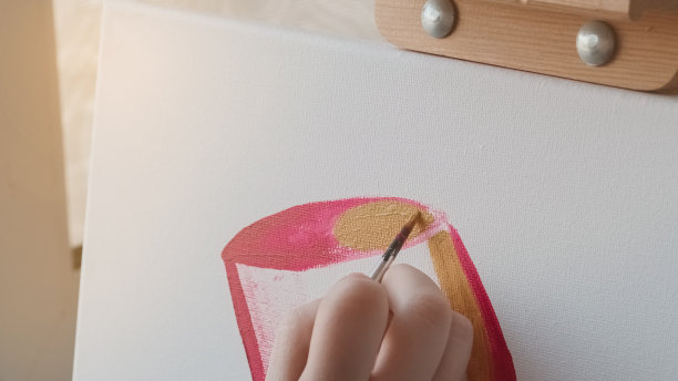 女性用画笔在画布上作画。图片下载