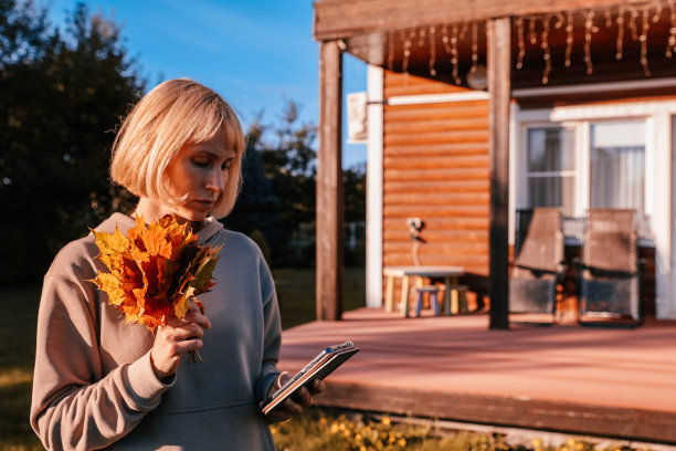 快乐的年轻靓女在秋日公园的户外散步，用手机聊天，色彩鲜艳。图片下载