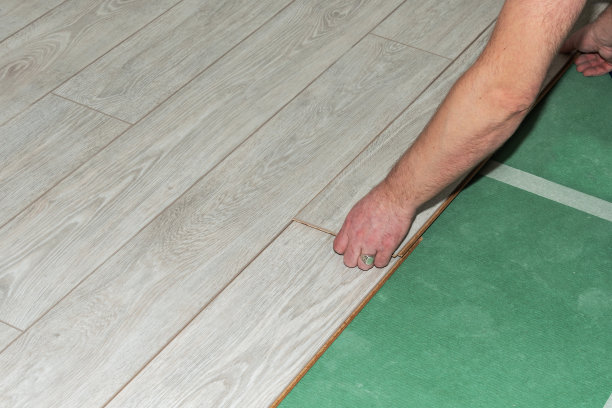 家居装修时在基材上铺设层压板。图片下载