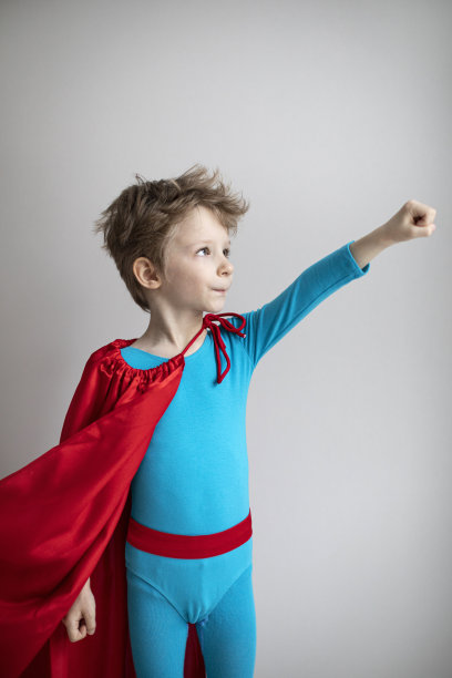 灰色墙上飞着的超级英雄小男孩。成功,动机图片下载