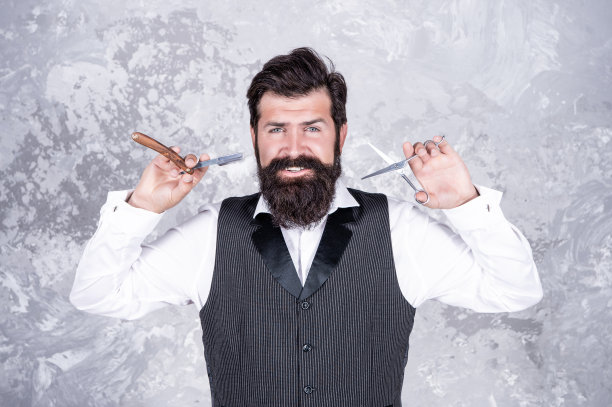 老式理发店。男性打扮。英俊的理发师用复古剃须刀。美发沙龙图片下载