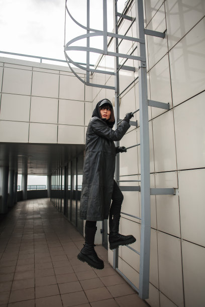 穿着黑色外套的时尚女孩在商业中心的屋顶上，以特工和间谍的形式出现图片下载