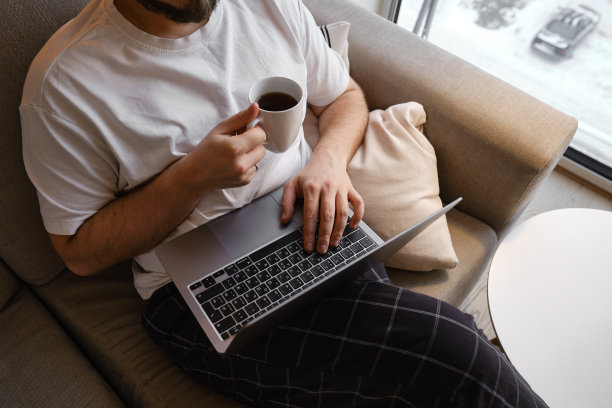 一个男人在桌子旁用笔记本电脑工作。在家远程工作。在办公室工作的商人。商业背景。家庭办公室图片下载