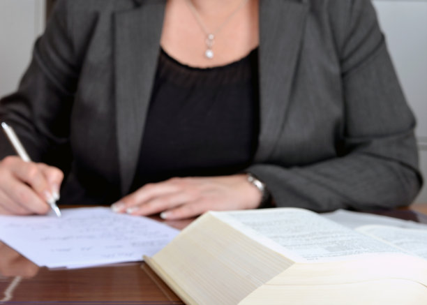 模糊剪影一个成功的女商人穿着黑色和灰色的职业装做文书工作的细节，选择性的焦点，背景图片下载