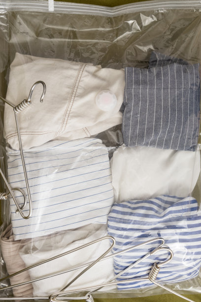 垂直形象的塑料真空袋保持服装，空衣架作为背景图片下载