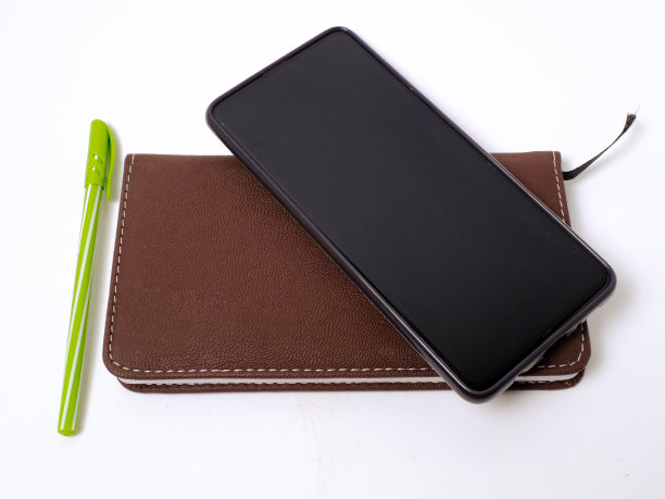 手机与皮套笔记本和笔在白色背景图片下载