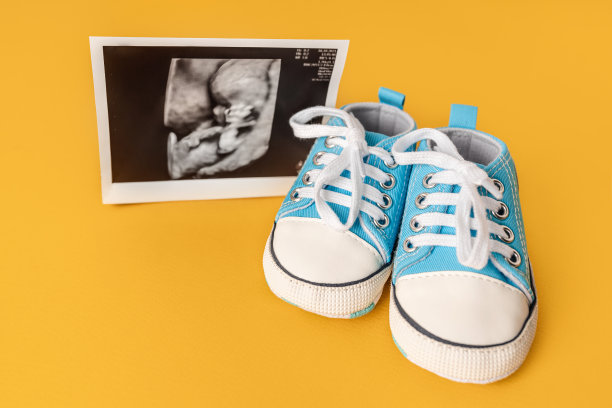 蓝色婴儿的运动鞋和一张超声波照片。美丽宝宝等待概念图片下载