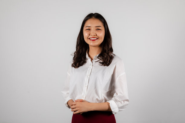 一个微笑的年轻亚洲妇女在白色背景的肖像图片下载